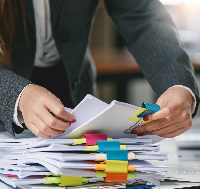 Radczyni prawna porządkująca dokumenty z kolorowymi zakładkami – analiza umów i dokumentacja firmowa.